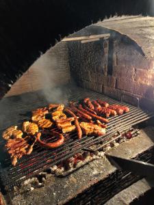 een grill met veel verschillende soorten voedsel op het bij Pensiunea PORTAS RESORT in Slănic