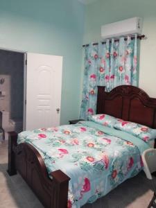 1 dormitorio con 1 cama con colcha de flores en Hotel Gazcue en Santo Domingo