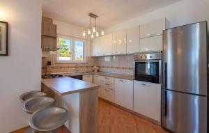 a kitchen with white cabinets and a stainless steel refrigerator at Luxury villa Liberta near Split, private pool in Podstrana