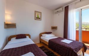 two beds in a room with a window at Luxury villa Liberta near Split, private pool in Podstrana +23 photos