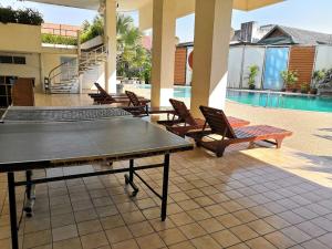 a ping pong table on a patio next to a pool at Near old city,Nimman,night Bazaar swimming pool apartment 25 in Chiang Mai