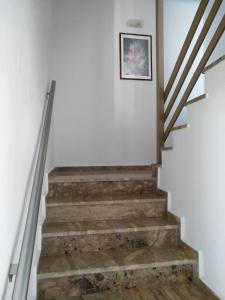 a stairwell with wooden steps and a picture on the wall at Calypso in Agia Roumeli