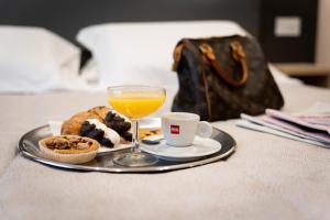 taca z jedzeniem i szklanka soku pomarańczowego w obiekcie Hotel Victoria w mieście Cuneo