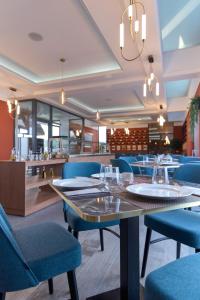 una sala da pranzo con tavolo e sedie blu di Rodizio Hill Resort a Cluj-Napoca