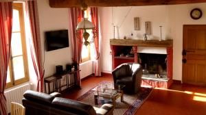 a living room with a couch and a fireplace at Gîte du Domaine du Ru in Aulnoy