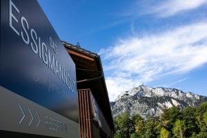 a sign for a building with mountains in the background at Hotel Das Essigmanngut in Anif