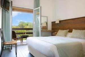 a bedroom with a large white bed and a balcony at San Giovanni in Porto-Vecchio