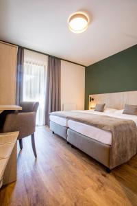 a hotel room with two beds and a window at Hotel Das Essigmanngut in Anif