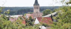 Alte Schmiede في Dunningen: مدينه صغيره فيها كنيسه مع برج