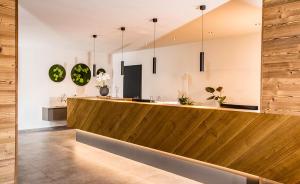 a lobby with a wooden counter with pendant lights at Hotel Das Essigmanngut in Anif