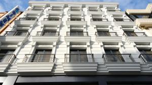 eine Fassade eines weißen Gebäudes mit Balkonen in der Unterkunft Dimen Hotel in Bursa