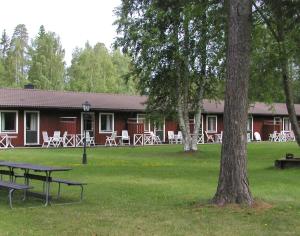 a building with tables and chairs in a park at Rättviks Golfby in Rättvik