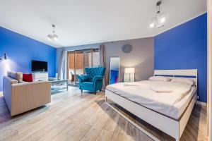 a bedroom with a large bed and a blue wall at Prywatne apartamenty Sun & Snow w Maloves in Władysławowo