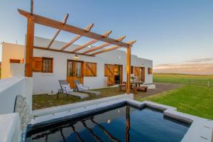 a house with a swimming pool in the yard at Denneboom Vineyards and Wildlife in Paarl