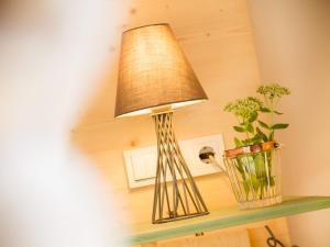 une lampe sur une étagère avec une plante et un vase dans l'établissement Krone Lautlingen, à Albstadt