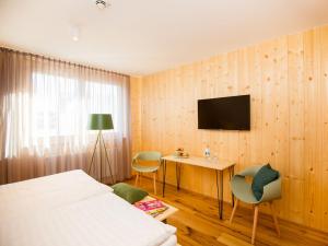 a bedroom with a bed and a desk and a television at Krone Lautlingen in Albstadt