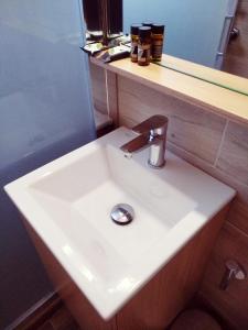 a white sink sitting under a bathroom mirror at Calypso in Agia Roumeli