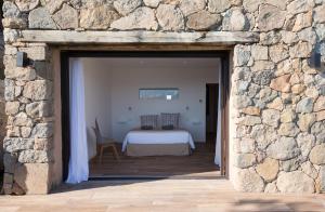 pared de piedra con una puerta que conduce a un dormitorio en Domaine Valle Doniche, en Olmeto
