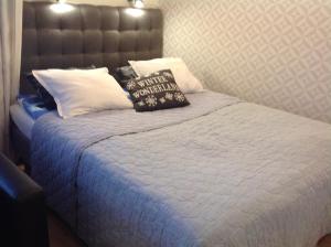 a bed with a white comforter and pillows at Lumi City Apartment in Levi