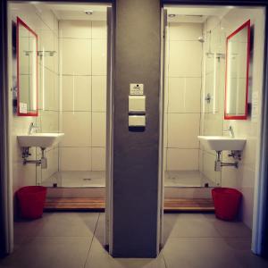 een openbare badkamer met 2 wastafels en 2 spiegels bij Ashanti Lodge Backpackers in Kaapstad