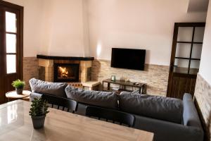 Una sala de estar con un sofá y una chimenea. en tuGuest Carataunas Apartment Alpujarra, en Carataunas