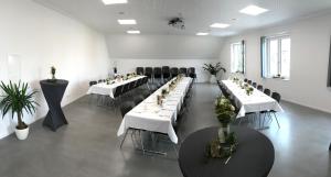 a large room with white tables and black chairs at Alte Schmiede in Dunningen