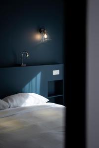 a blue bedroom with a bed and a lamp at Beverly Hills Hotel in Brussels