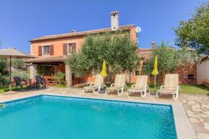 a villa with a swimming pool and a house at Beautiful stone istrian villa Anamaria with pool near the beach in Šišan