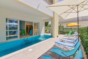 een zwembad met 2 ligstoelen en een parasol bij Apartments Villa Ema in Zadar