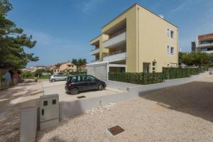 een auto geparkeerd op een parkeerplaats voor een gebouw bij Apartments Villa Ema in Zadar