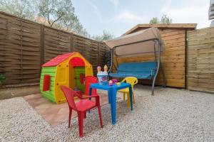een achtertuin met een tafel en stoelen en een tent bij Apartments Villa Ema in Zadar