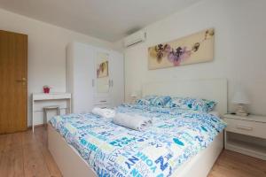 een slaapkamer met een bed met blauwe en witte lakens bij Apartments Villa Ema in Zadar +83 foto's