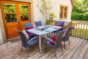 a table and chairs sitting on a deck at Bonnie Banks Cottage in Balloch