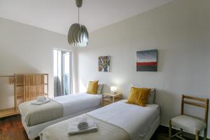 a room with two beds and a chair in it at LovelyStay - Spacious 3BR Flat with AC and Balcony in Porto