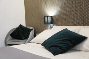 una camera d'albergo con due letti e una sedia di Agathae Dreams a Catania