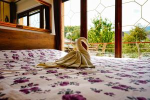 una bata en una cama con ventana en The View Apartment, en Visoko