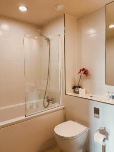 a white bathroom with a shower and a toilet at Apartment 11 Popeshead Court in York