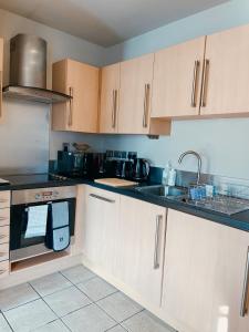 eine Küche mit Holzschränken und einem Waschbecken in der Unterkunft Apartment 11 Popeshead Court in York