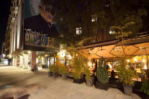 a building with a bunch of potted plants on a street at Kombinat Rooms City Center in Novi Sad