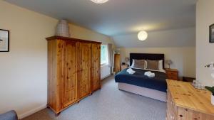 En eller flere senge i et værelse på Woodlands Cottage