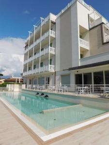 um hotel com piscina em frente a um edifício em Hotel Oceano em Marina di Pietrasanta