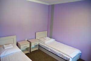 two beds in a room with purple walls at Kompleks Rekreacyjno-Wypoczynkowy i Restauracja STRUMYK in Jordanów +31 photos