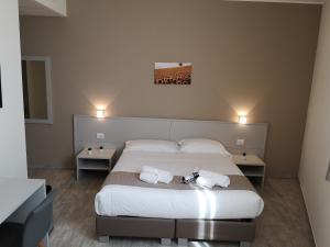 Hotel & Wellness Stella Delle Langhe في جوفونه: غرفة نوم عليها سرير وفوط