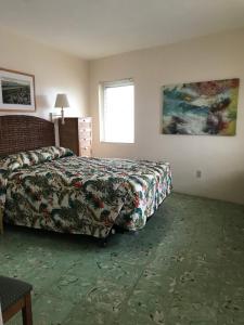 a hotel room with a bed and a window at El Patio Motel in Key West