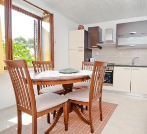 a kitchen with a wooden table and four chairs at Apartment Maja in Mali Lošinj