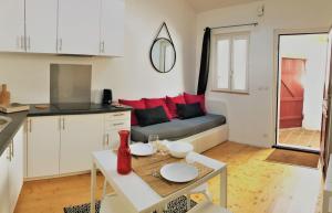 een keuken en een woonkamer met een bank en een tafel bij La maisonnette de la Concorde au cœur de Moissac in Moissac