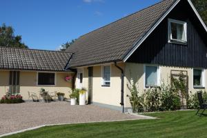 ein Haus mit einem schwarzen Dach und einem Hof in der Unterkunft Perslunds B&B in Laholm