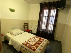 a small bedroom with a bed and a window at Hotel Normandy in Dreux