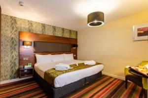a hotel room with a bed and a lamp at Holiday Inn Newcastle-Jesmond, an IHG Hotel in Newcastle upon Tyne