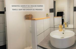 a white bathroom with a sink and a mirror at La maisonnette de la Concorde au cœur de Moissac in Moissac